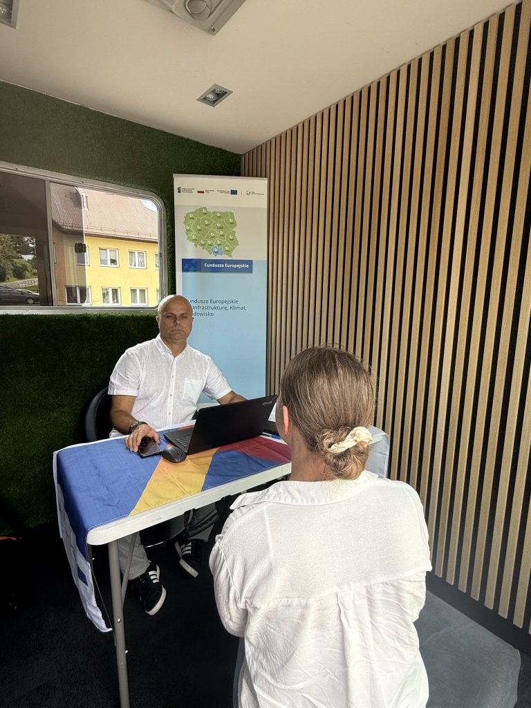 doradca energetyczny siedzi przy stole w mobilnym punkcie doradczym