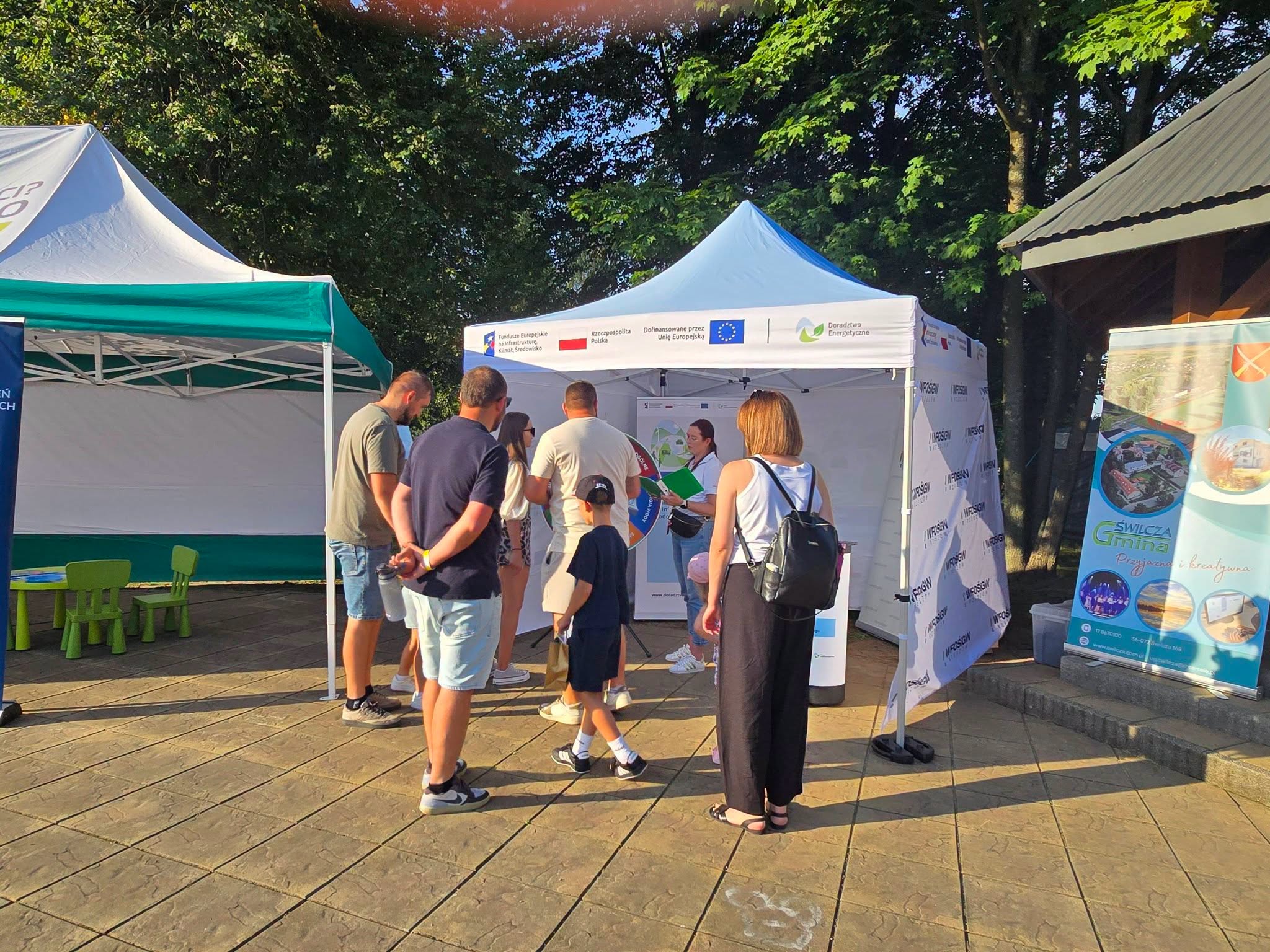 Zdjęcie przestawia stoisko informacyjno-promocyjne Wojewódzkiego Funduszu Ochrony Środowiska i Gospodarki Wodnej w Rzeszowie w ramach Projektu Doradztwa Energetycznego na evencie Dni Gminy Świlcza 2026 w dniu 25 lipca